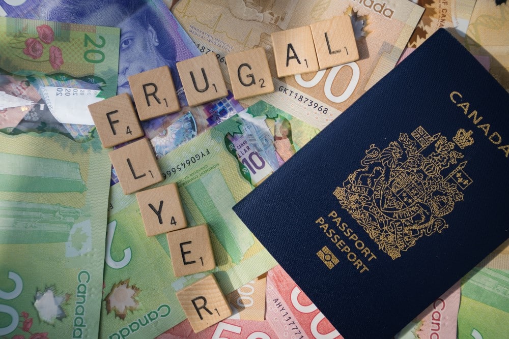 Frugal Flyer scrabble letters with Canadian passport and cash money