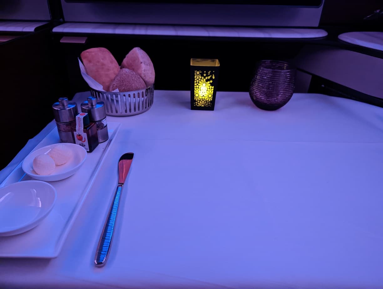 qatar airways qsuite meal setting with candle