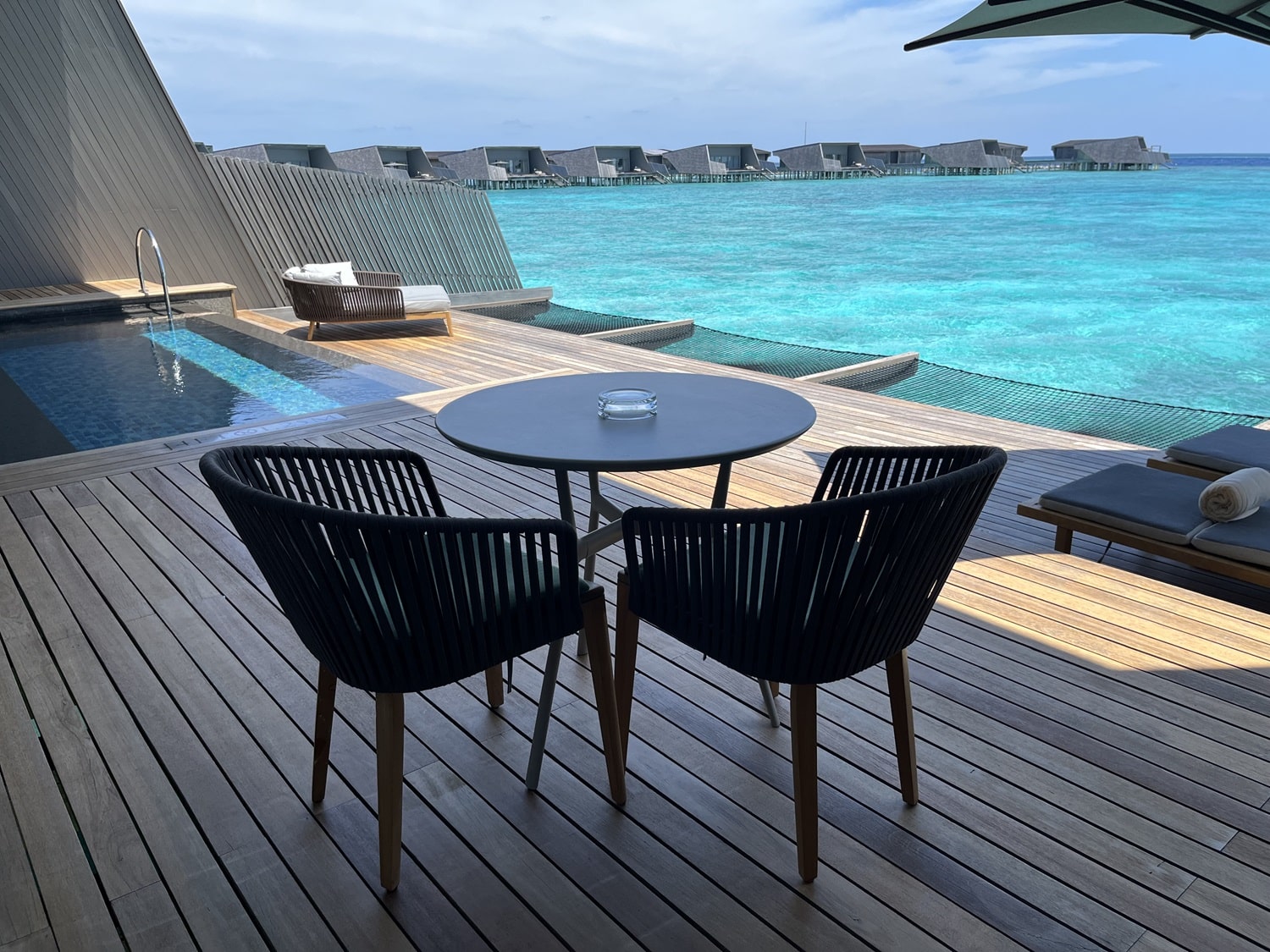 st regis maldives vommuli resort overwater bungalow table on deck