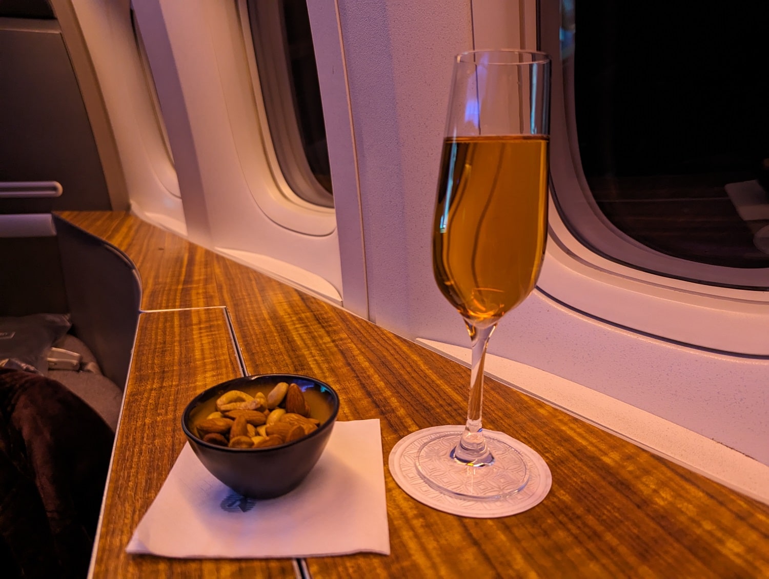 qatar airways first class 777-300er rose champagne with warm mixed nuts
