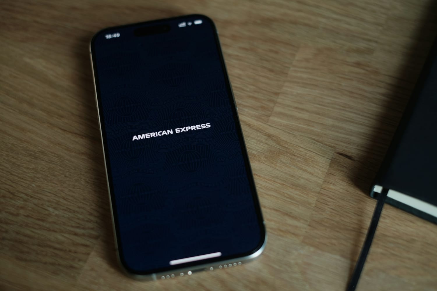 american express mobile app loading on phone on desk