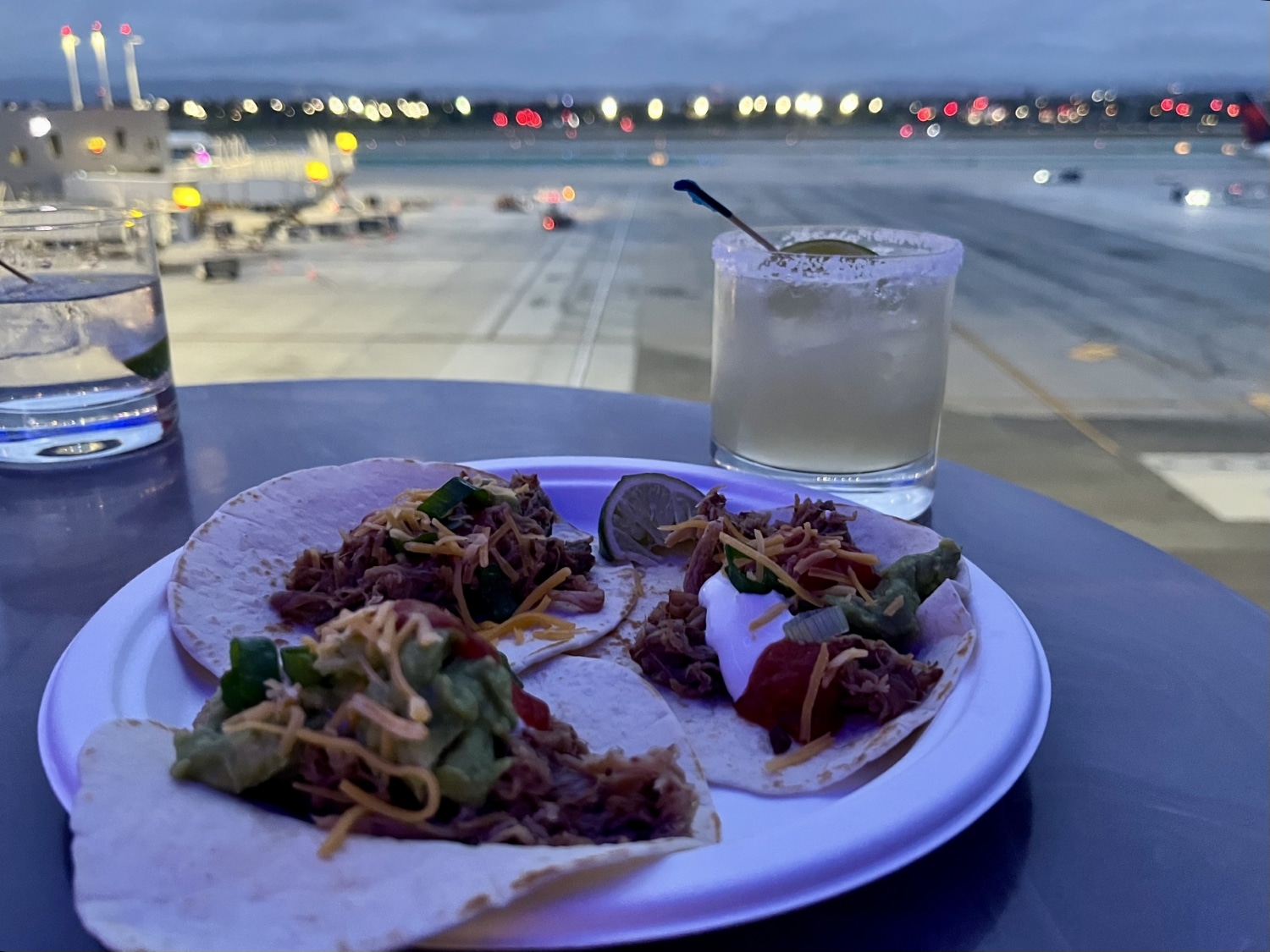tacos and margaritas at delta sky club with view of tarmac