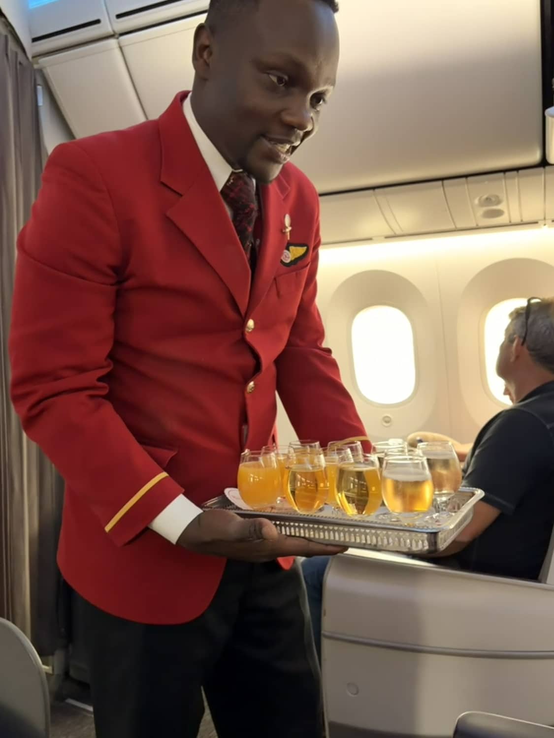 kenya airways business class 787-8 flight attendant with welcome beverages on tray