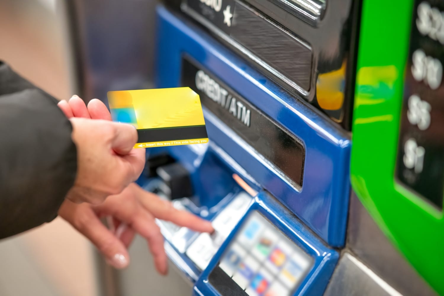 person using a debit card at an atm