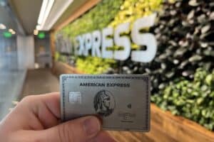 american express platinum card being held in front of amex centurion airport lounge entrance