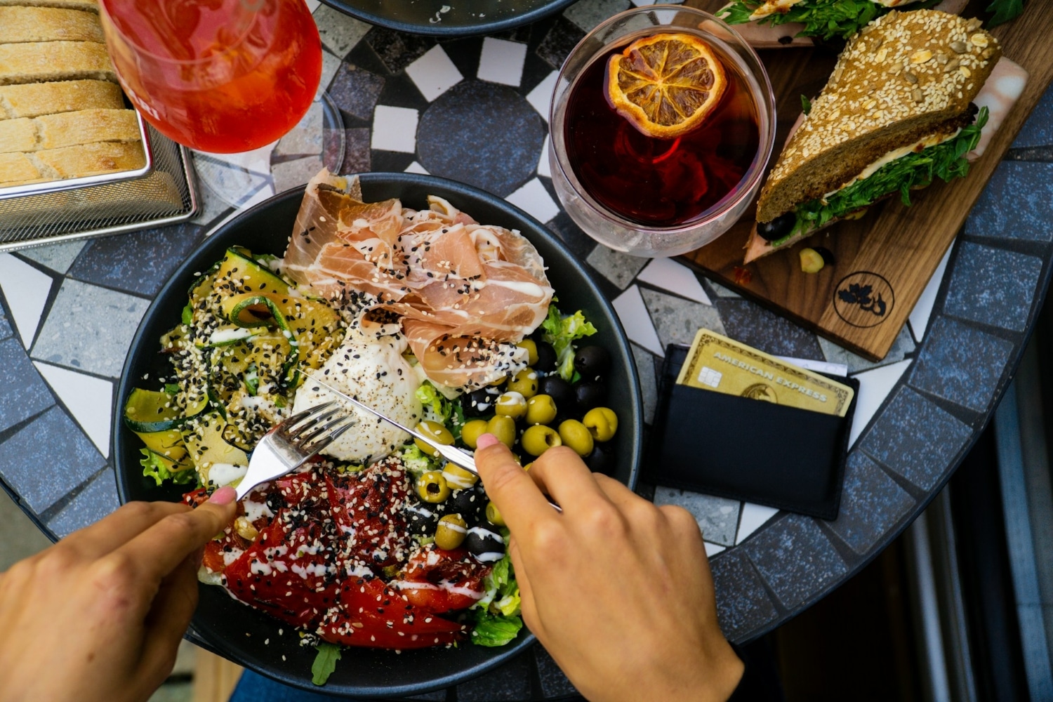 amex gold card on table next to meal and drink