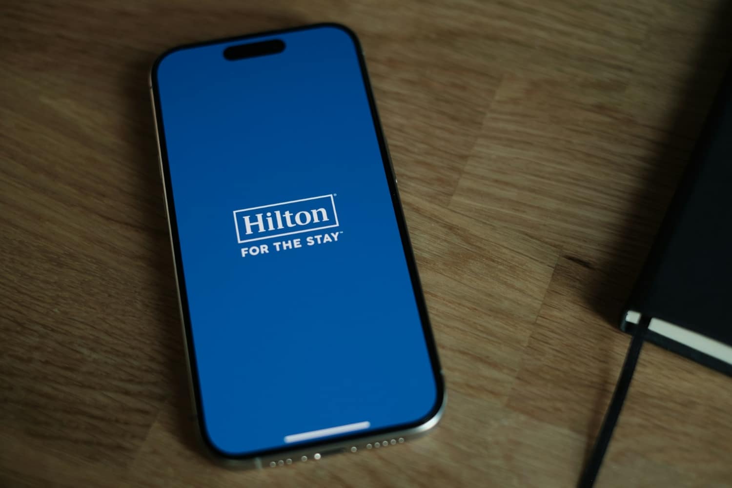 hilton app loading on phone on desk