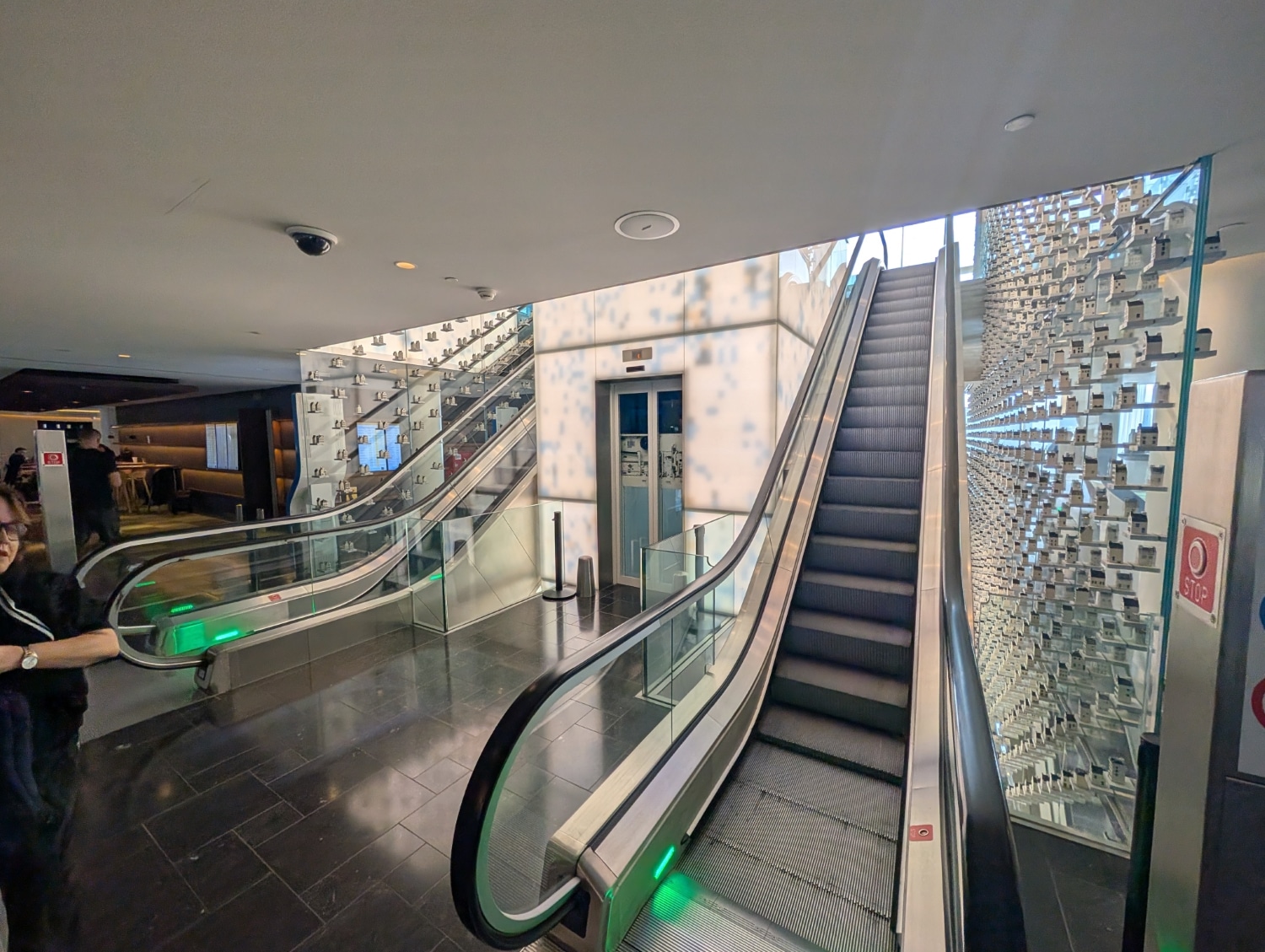 klm crown lounge amsterdam escalators with dutch houses in wall