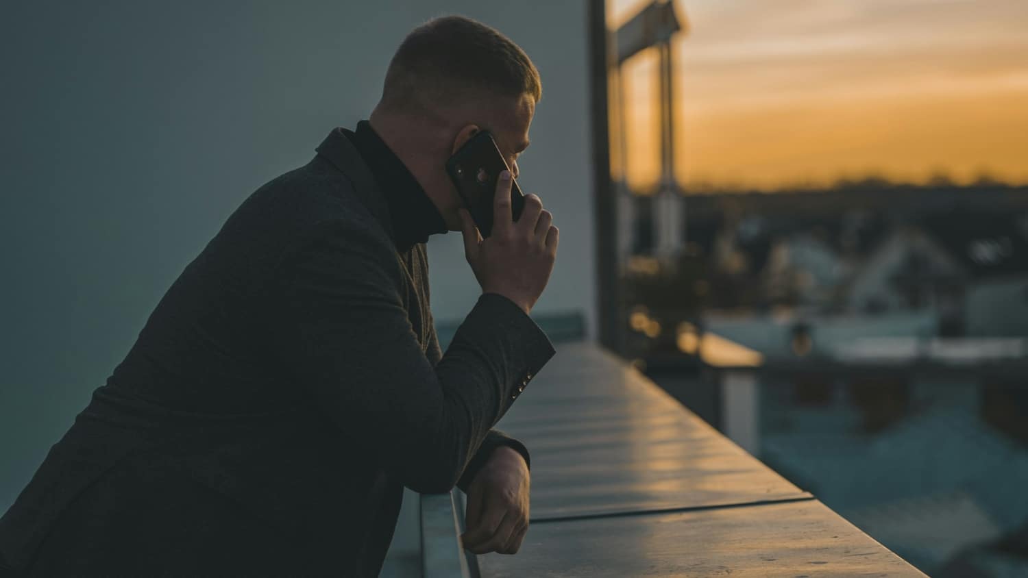person talking on cell phone on residential balcony