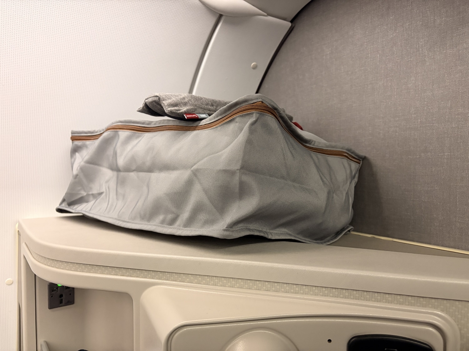 american airlines flagship first class bedding stored on shelf behind seat