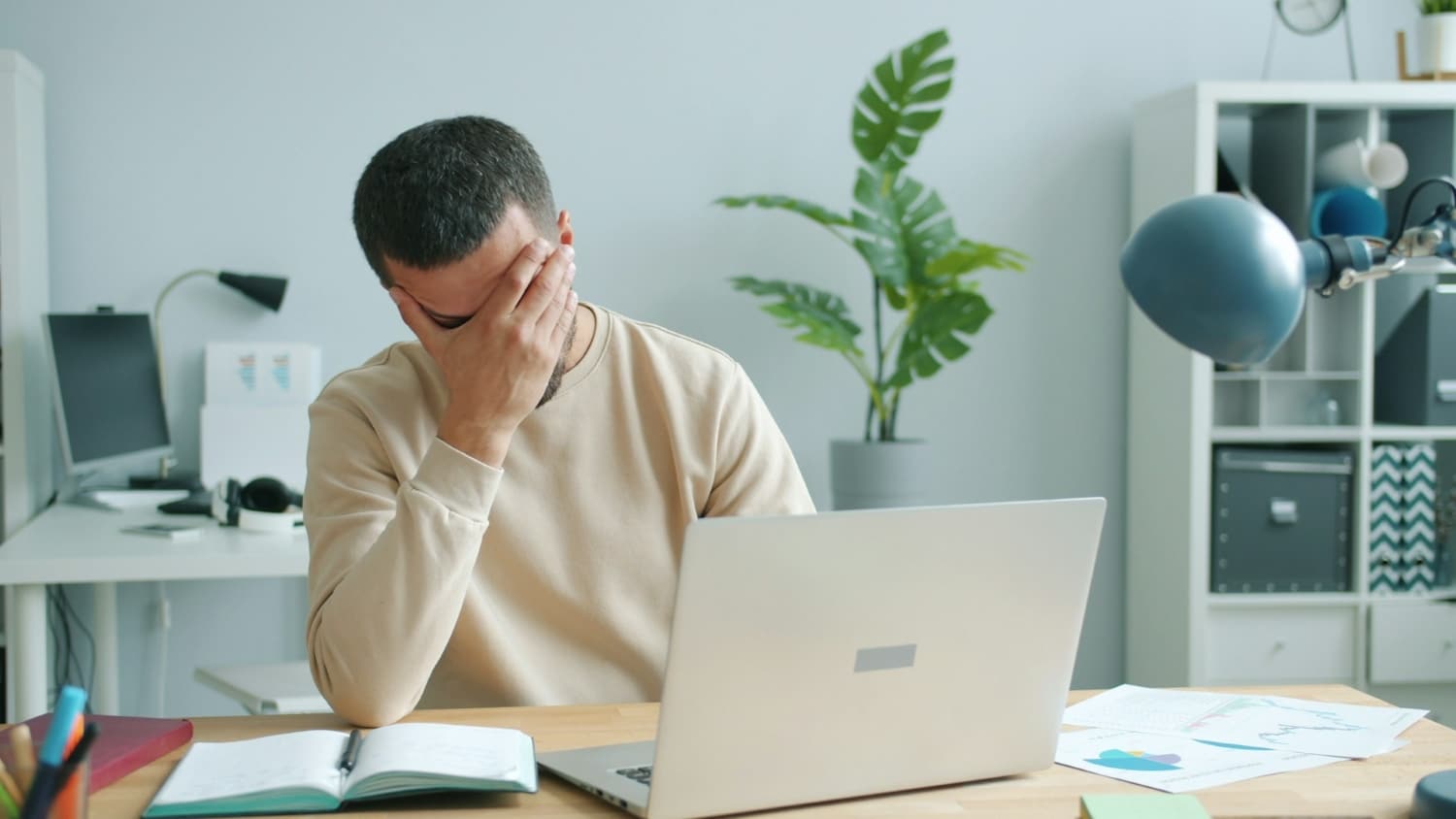 person with head in hand after being declined for a credit card application on laptop