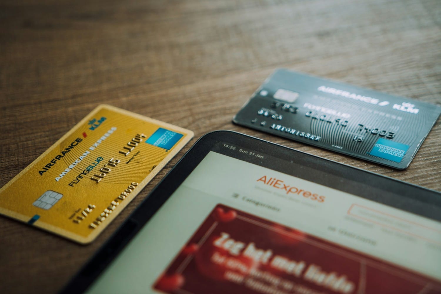 american express credit cards on desk with a tablet