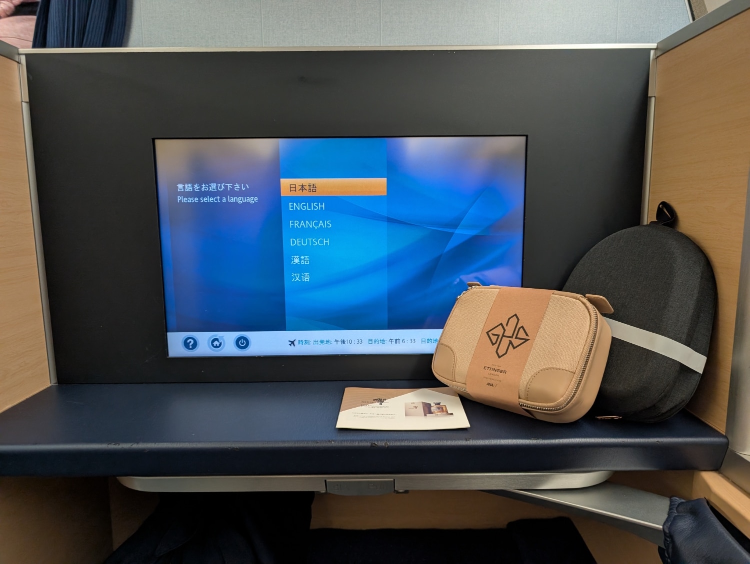 ana first class 777-300er entertainment console with amenity kit and headphones