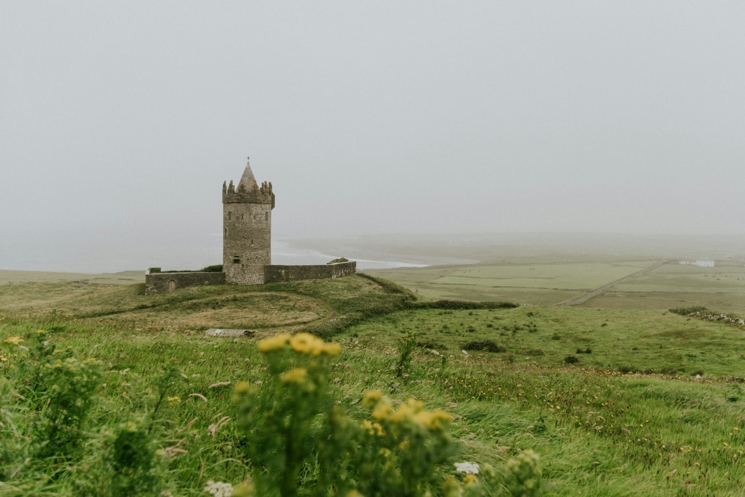castle in a grassy field in ireland