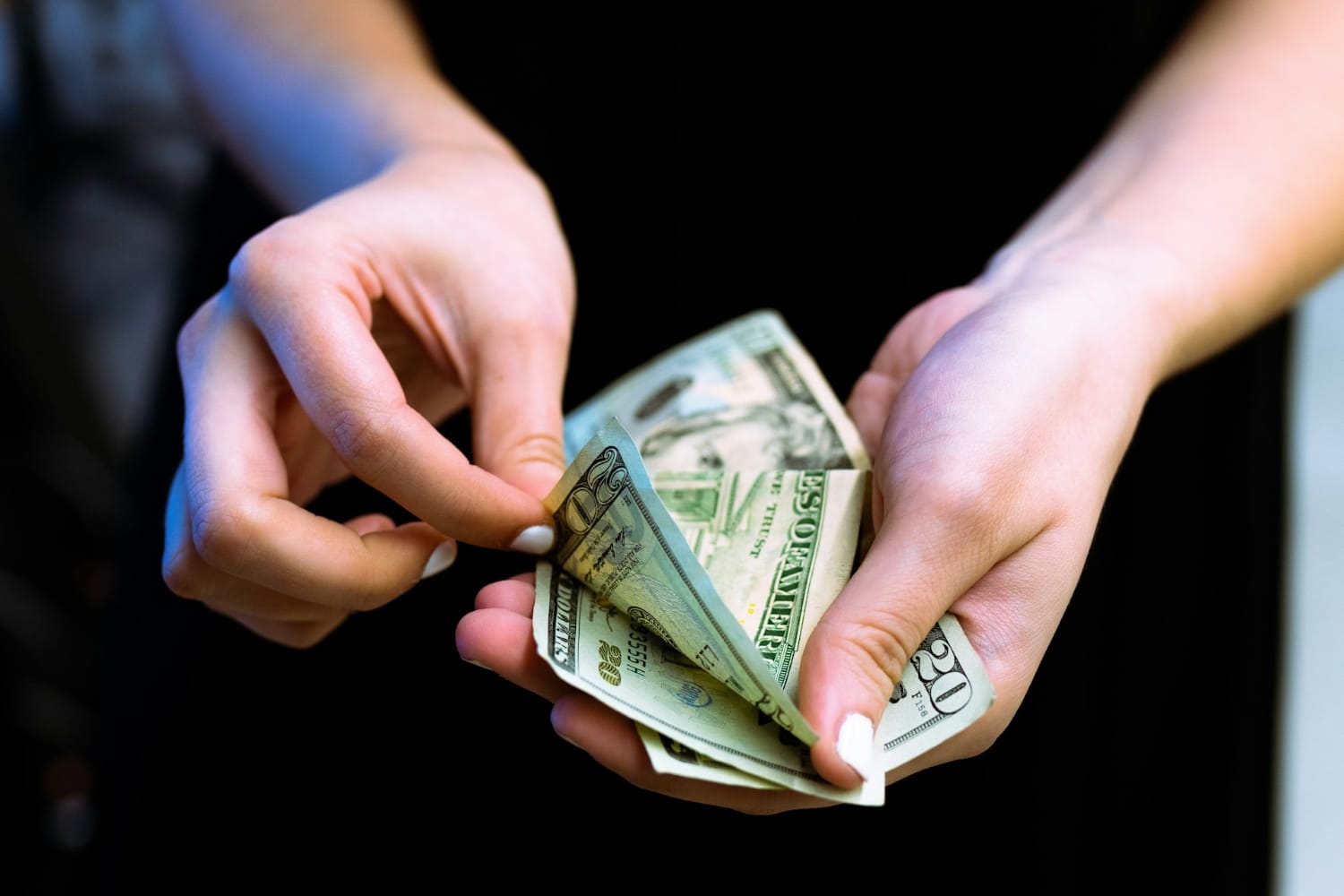 person counting and paying with us currency bills