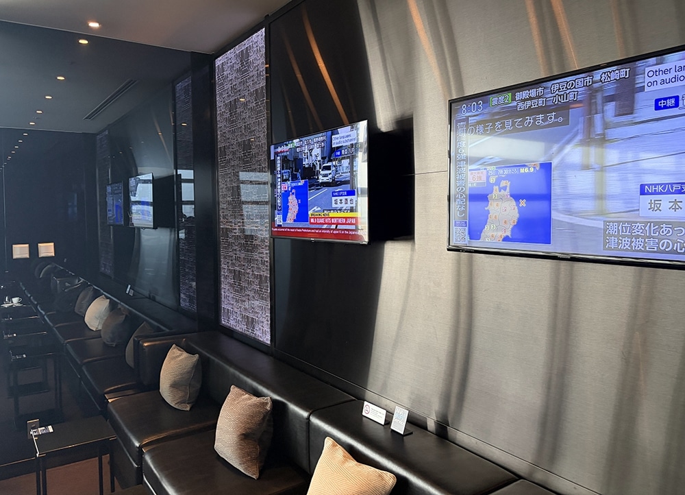 ana suite lounge haneda earthquake notification on television screen