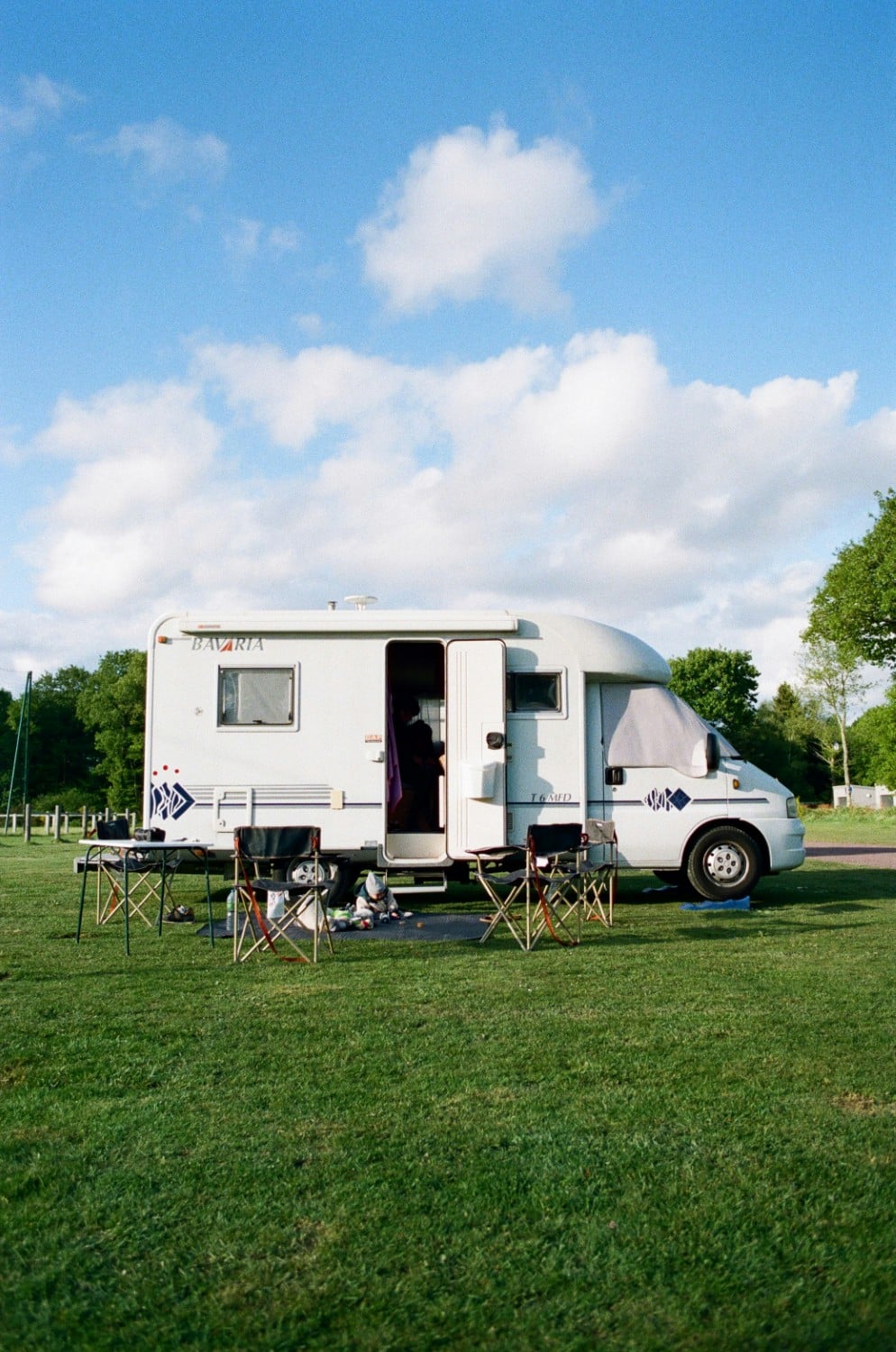camper van parked with chairs outside